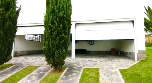 Puerta enrollable blanca abri&eacute;ndose en el garaje de una vivienda