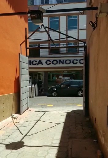 Port&oacute;n batiente abri&eacute;ndose con motor LiftMaster y brazo articulado de carrito loco en el ingreso de un local