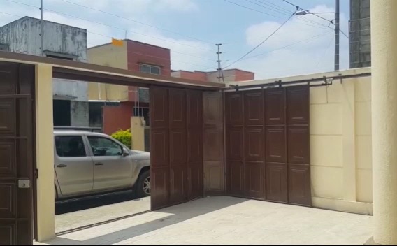Puerta seccional lateral de madera plegando contra el muro del garaje